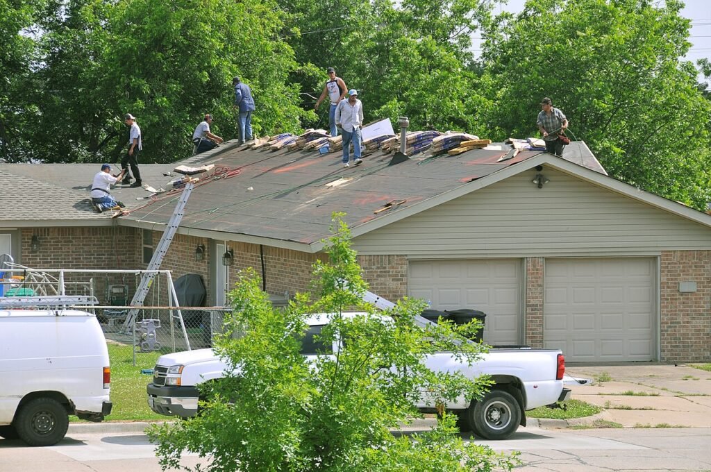 Roofing crew replacing shingles on a house