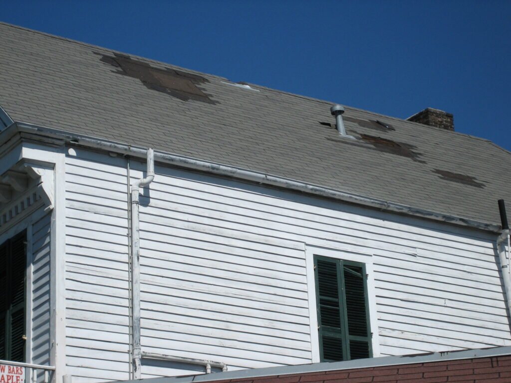 Missing shingles and exposed underlayment after wind damage
